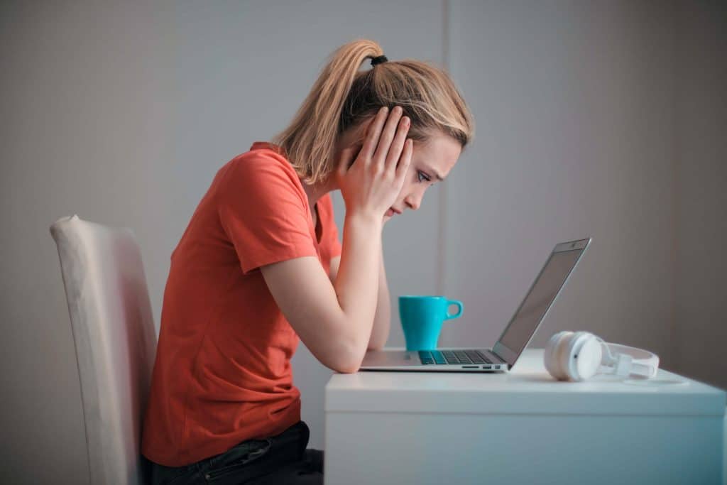 Woman at computer looking very stressed